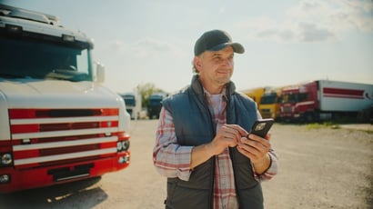 Truck driver checking a digital indemnity payment notification on his phone